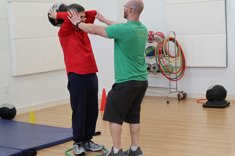 Two men practicing a self-defense move indoors.