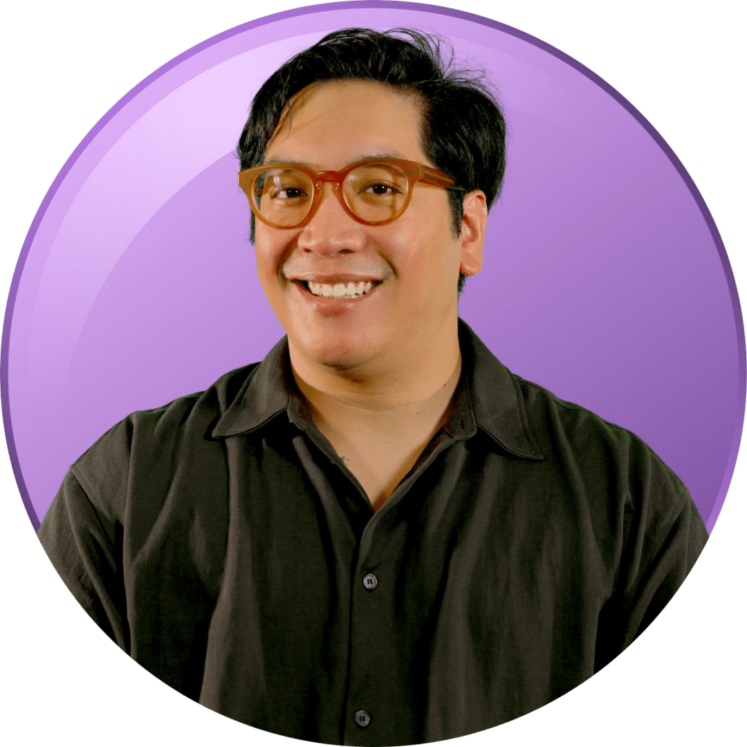 Smiling man with glasses against purple background.