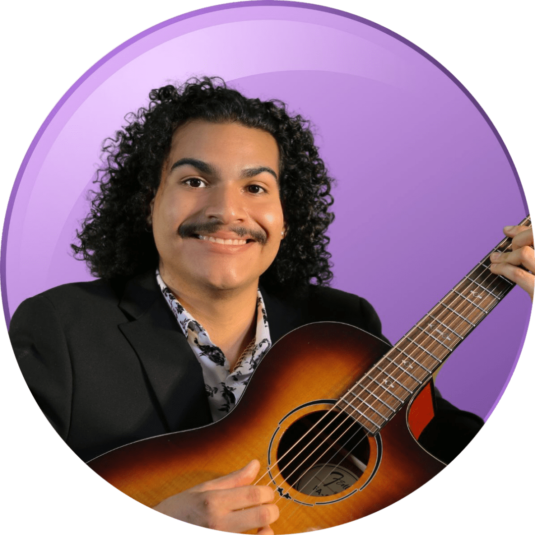 Man with curly hair playing acoustic guitar against a purple background.
