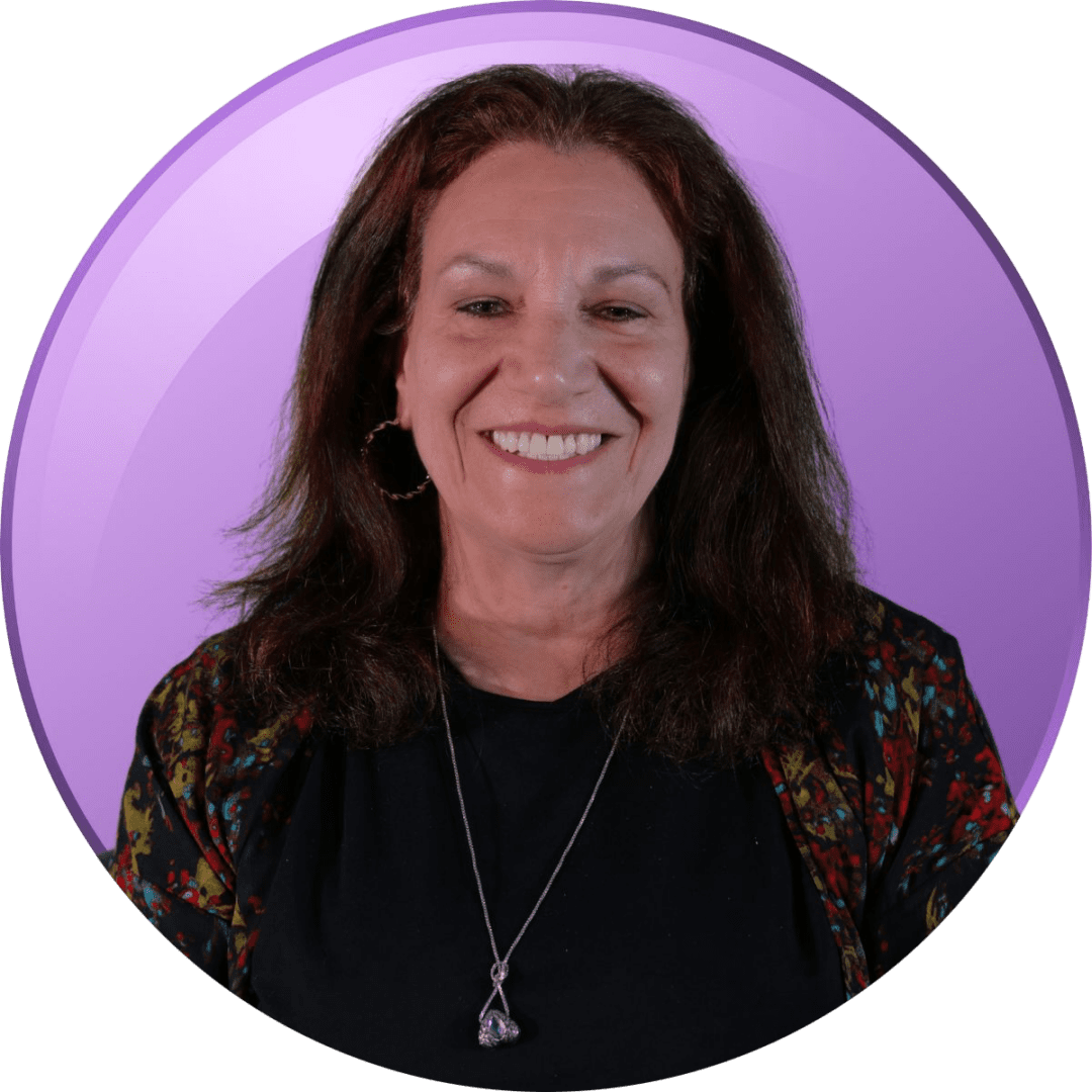Smiling woman in a black top with a purple background.
