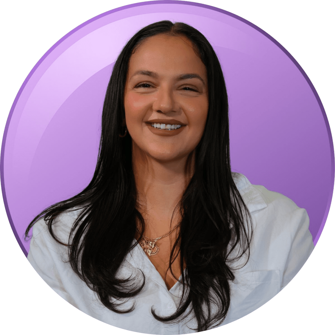 Portrait of a smiling woman with long dark hair against a purple background.