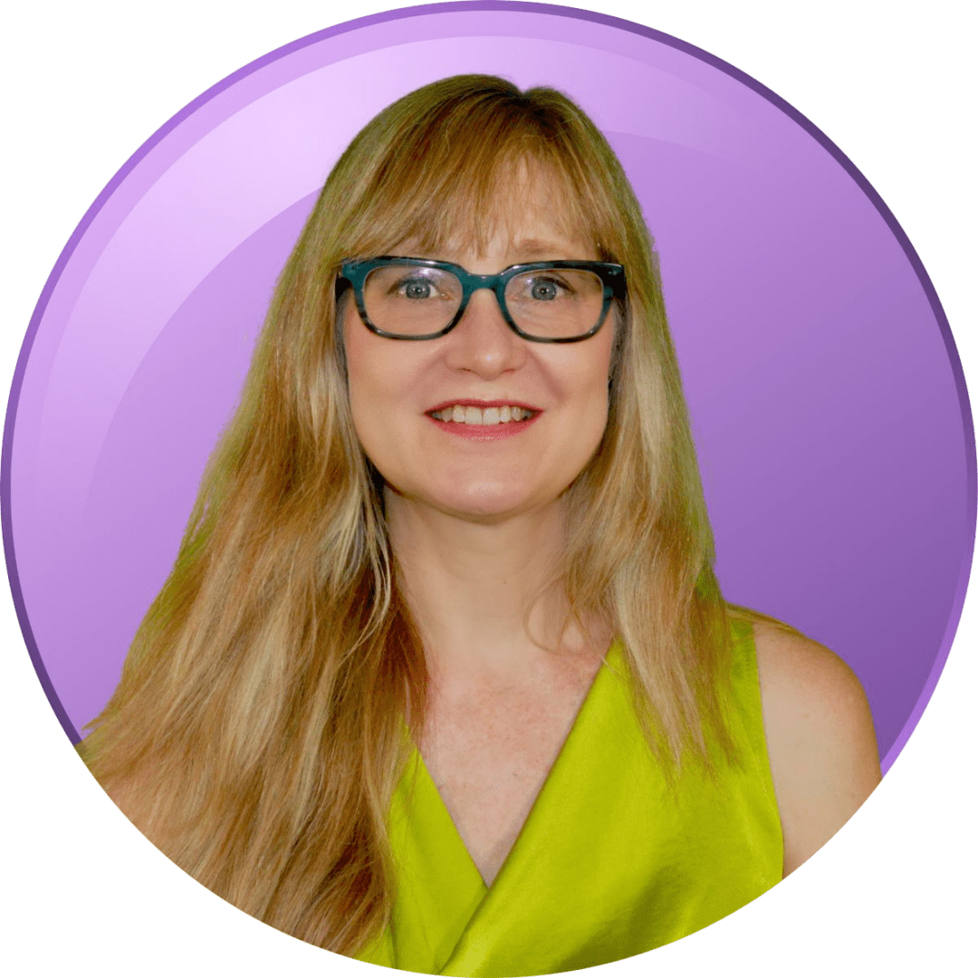 Smiling woman with glasses and long blonde hair in a green top.