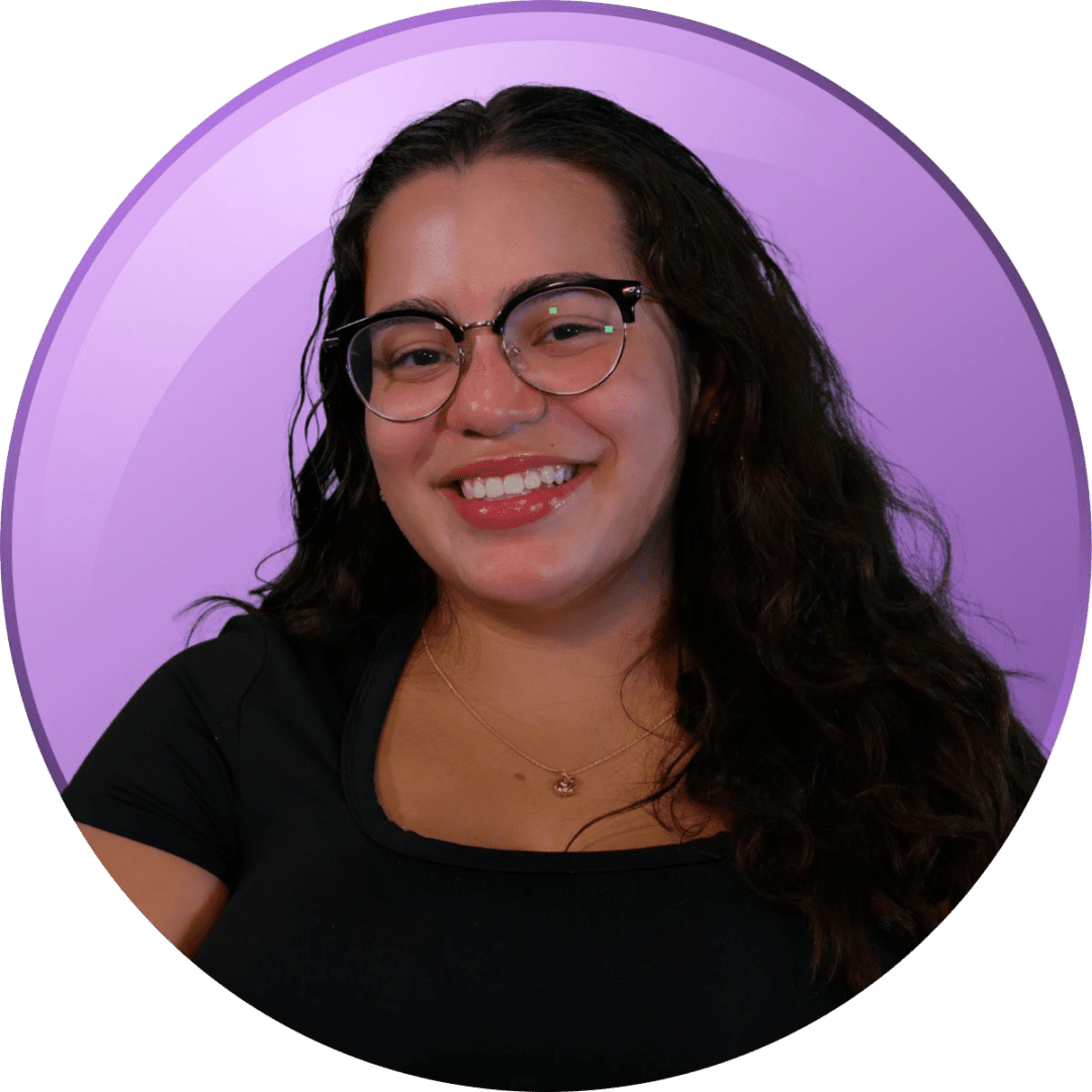 Smiling woman with glasses against a purple background.